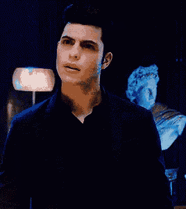 a man in a black shirt stands in front of a statue