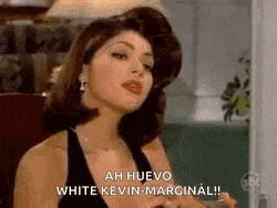 a woman in a black dress is sitting in a chair and talking to a man .