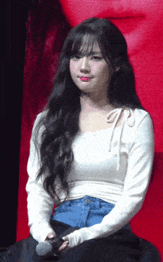a woman with long hair is holding a microphone