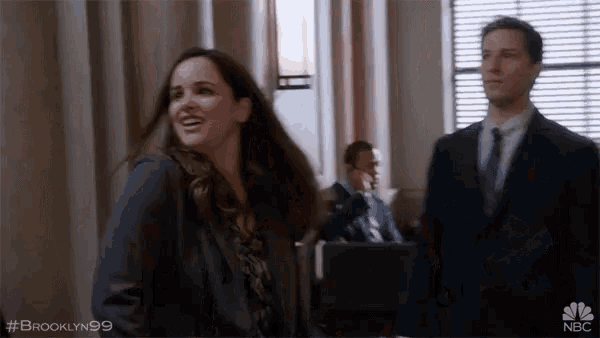 a man and a woman are standing next to each other in a room . the woman is smiling .