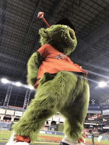 a green teddy bear wearing an orange shirt that says ' gsd ' on it