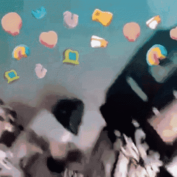 a bunch of candy hearts are floating in the air above a phone