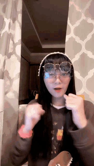 a girl wearing glasses and a sweater with a picture of a bear on it