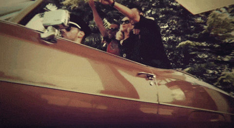 a group of people are riding in a car and one of them is wearing a hat that says ' a ' on it