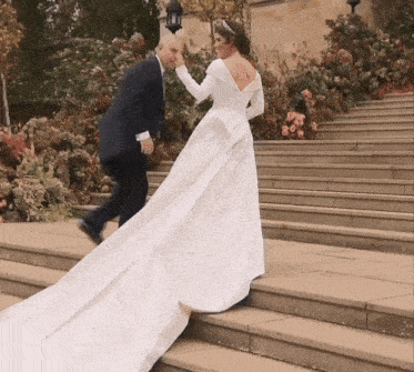 a bride and groom are walking down a set of steps