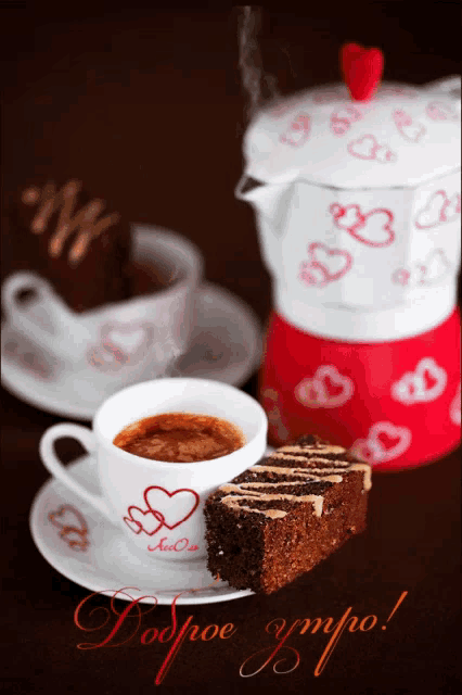 a cup of coffee next to a piece of cake and a pot with hearts on it
