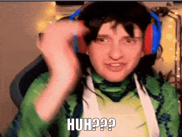 a man wearing headphones and a green shirt is making a funny face and saying huh ?