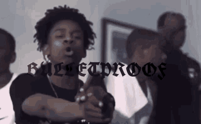 a group of young men are standing next to each other in a room and one of them is making a funny face .