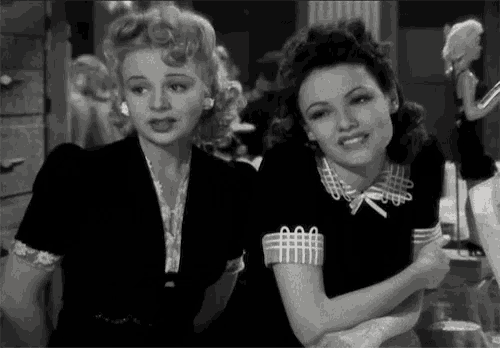 two women are sitting next to each other and one has a collar that says aaa