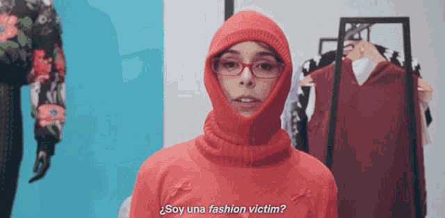 a woman wearing glasses and a red sweater with the words soy una fashion victim below her