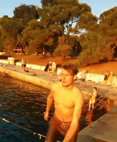 a shirtless man is jumping into the water