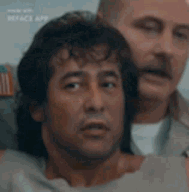 a man in a hospital gown is sitting next to another man in a hospital gown .