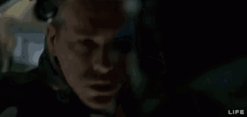 a man and a woman are looking out of a window in a spaceship .