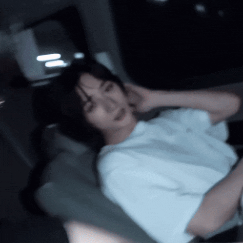a blurry picture of a person laying down with their hands on their head