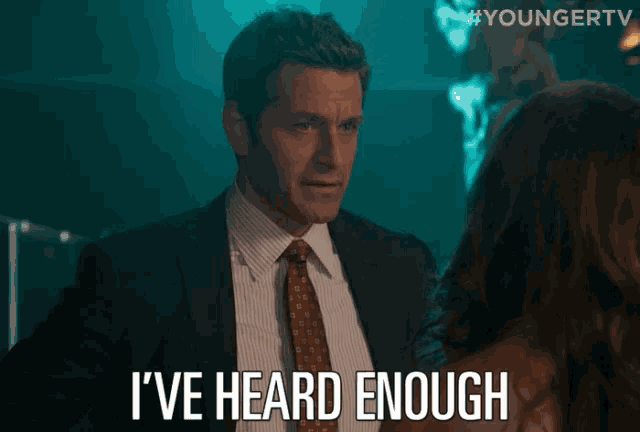 a man in a suit and tie says i 've heard enough in front of a woman
