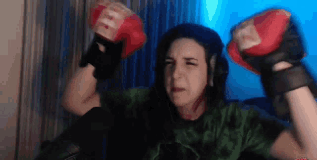 a woman is wearing boxing gloves and making a face