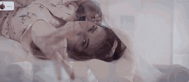 a woman is laying on a bed with the word indigo on the bottom right