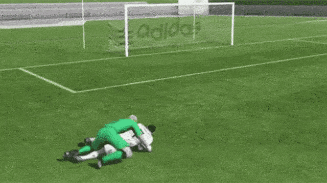 a soccer goalie is trying to stop a soccer ball from going into the net with the word adidas on it