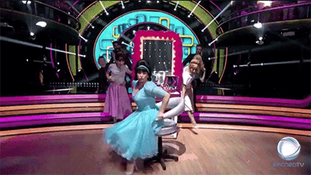 a woman in a blue dress is dancing on a stage with a sign that says globotv