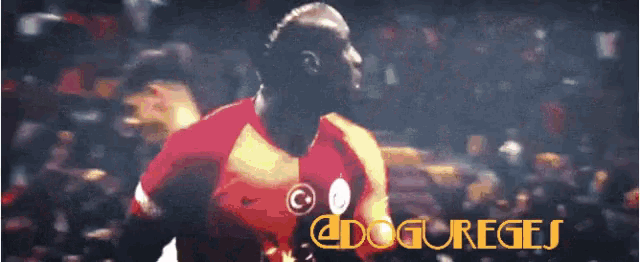 a soccer player in a red and yellow jersey with the word doguregis on the bottom