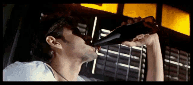 a man drinking from a bottle that says coca cola