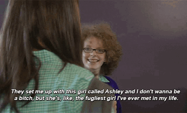 a girl with curly hair and glasses is talking to a man with long hair