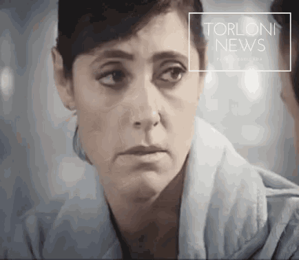 a close up of a woman 's face with the words torloni news written above her