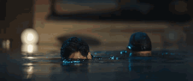 a man is laying in the water with a gun