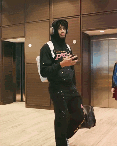 a man wearing headphones and a hoodie that says ' peace ' on it