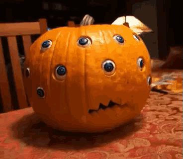 a pumpkin with a face carved into it and blue eyes