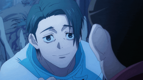 a man in a blue shirt is looking at another man in a dark room
