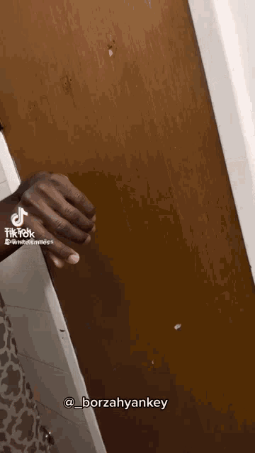 a tiktok video of a person holding a door