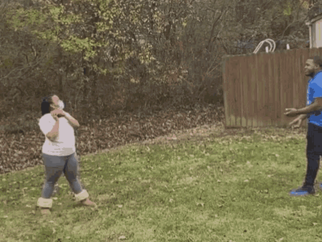 a man in a blue shirt is throwing pink powder in a yard