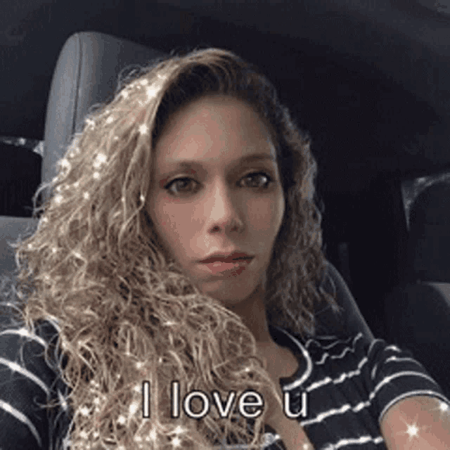 a woman is sitting in a car and says i love you