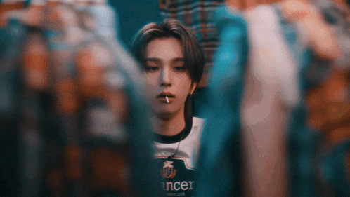 a young man with a cigarette in his mouth wears a shirt that says cancer