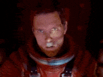 a man in a space suit is standing in a room with a computer