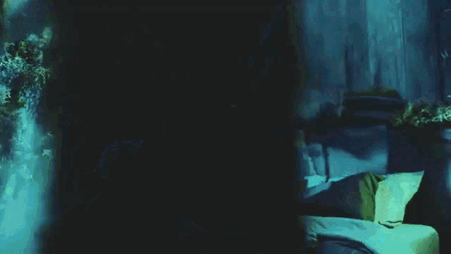 a man and a woman are sitting on a bed in a dark room .