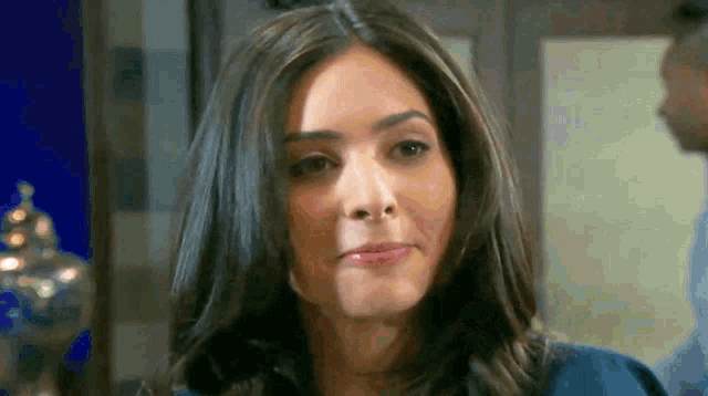 a close up of a woman 's face with a man behind her .