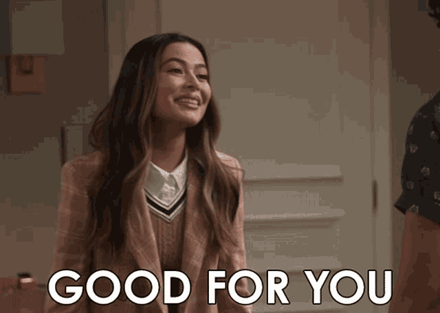 a woman in a pink jacket stands in front of a door that says " good for you "