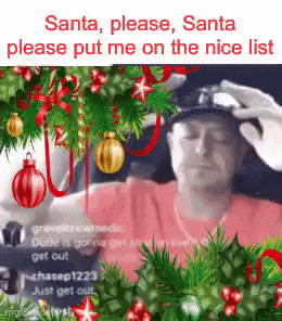a man is sitting in front of a christmas tree with a person putting a hat on his head .