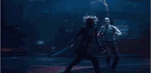 a man and a woman are fighting in a dark room .