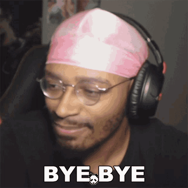a man wearing headphones and a pink headband says " bye bye "