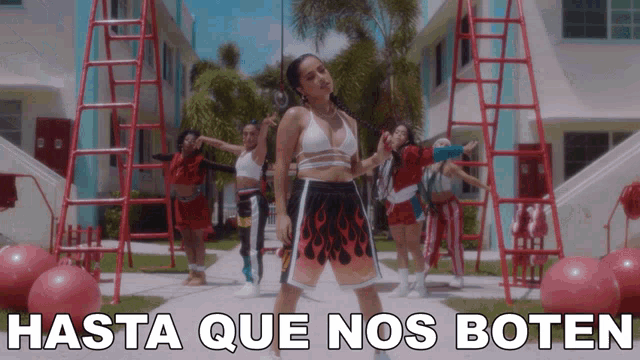 a woman is dancing in front of a sign that says hasta que nos boten