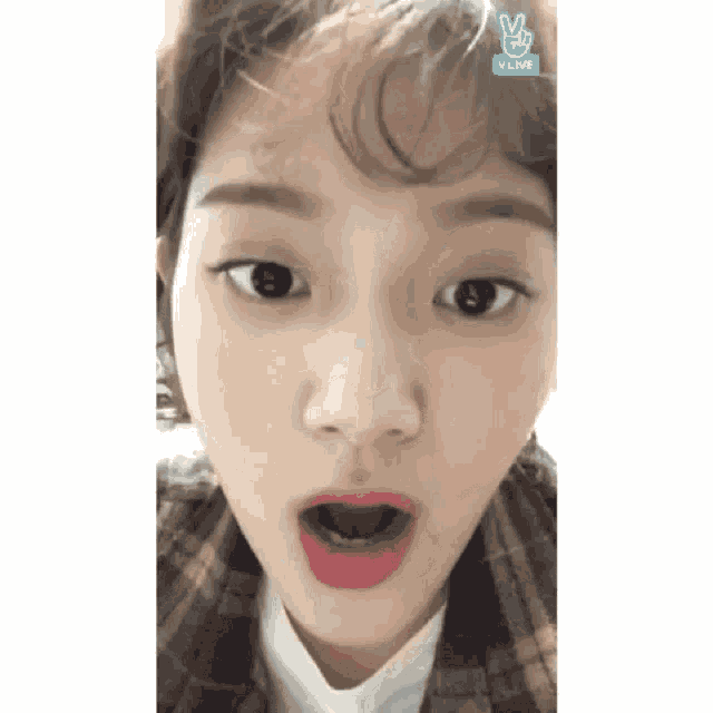 a close up of a woman 's face with a v live logo on the bottom right