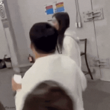 a man and a woman are standing next to each other in a room with a chair .