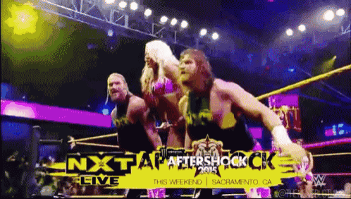 wrestlers in a ring with a sign that says nxt
