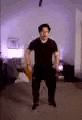 a blurry picture of a man in a black shirt standing in a living room .