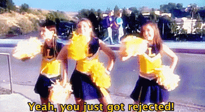 a group of cheerleaders are dancing on a sidewalk and one of them says yeah , you just got rejected
