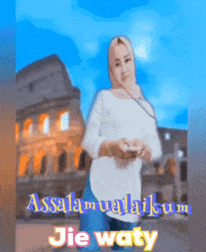a woman in a hijab is holding a cell phone in front of a building that says assalamualaikum jie waty