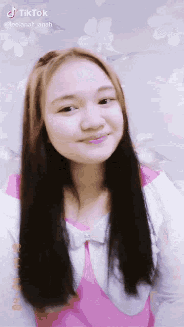 a tiktok video of a girl with long hair and a pink top